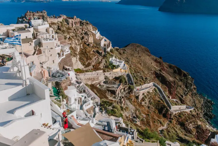 Village of white houses spread along the clifftop above the sea in Santorini