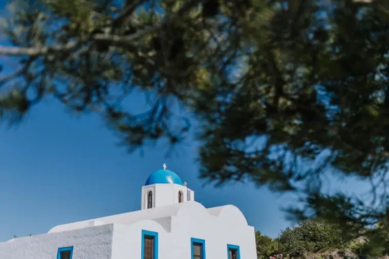 Small blue-domed chapel framed by pine branches