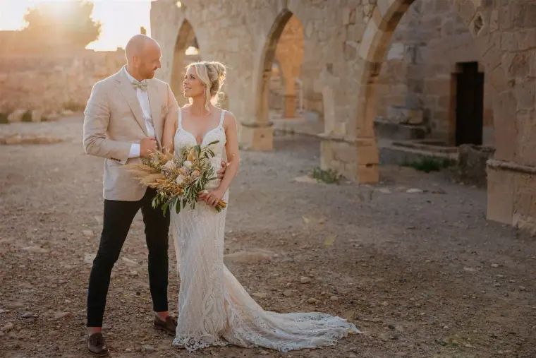 Couple gazing at each other among ancient stone arches