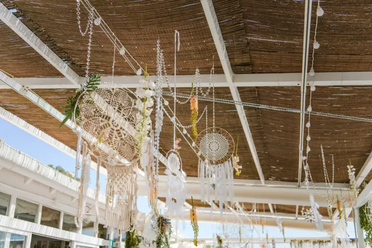 Dreamcatchers and macramé hanging beneath a reed-roofed beach terrace