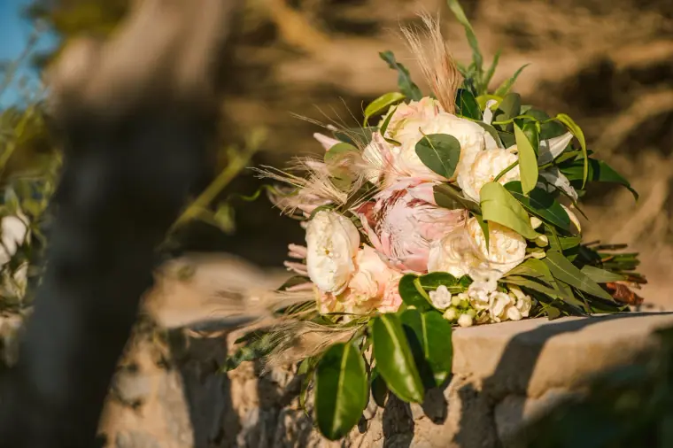 Close-up of a bouquet of peach roses and greenery in golden light