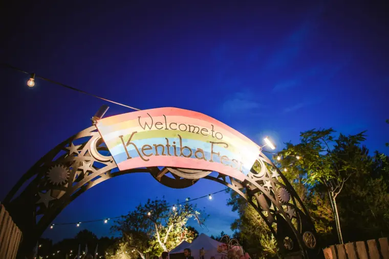 Illuminated arch reading Welcome to KentibaFest at night