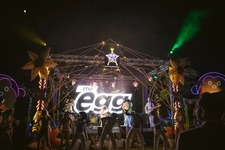 Festival stage with The Egg sign, lasers and dancers at night