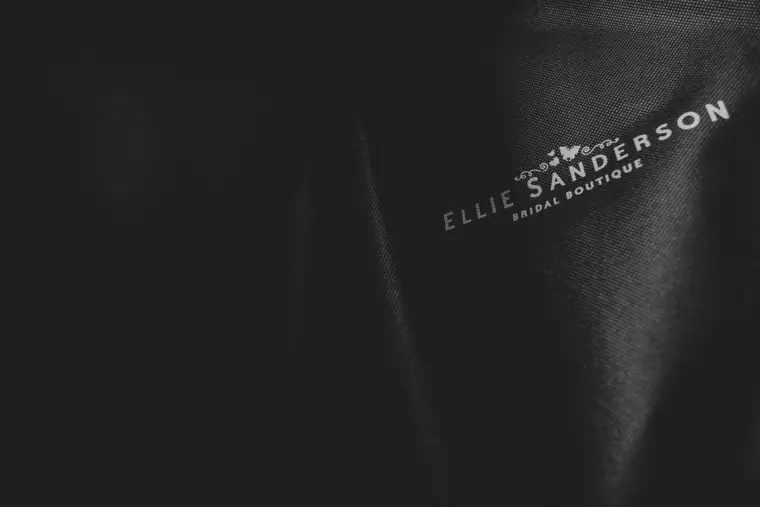 Black garment bag embossed with the Ellie Sanderson Bridal Boutique logo