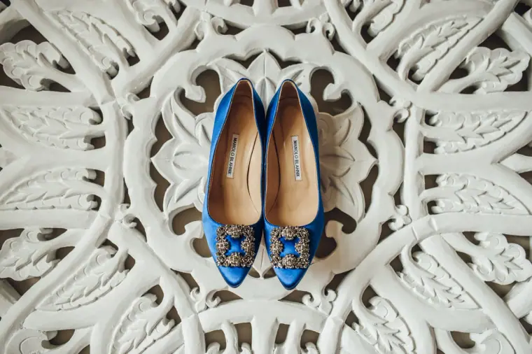 Blue satin shoes with jewelled buckles on a carved white panel