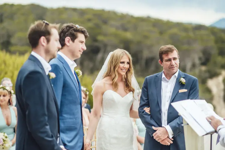 Bride, groom and best man standing before the celebrant at the ceremony