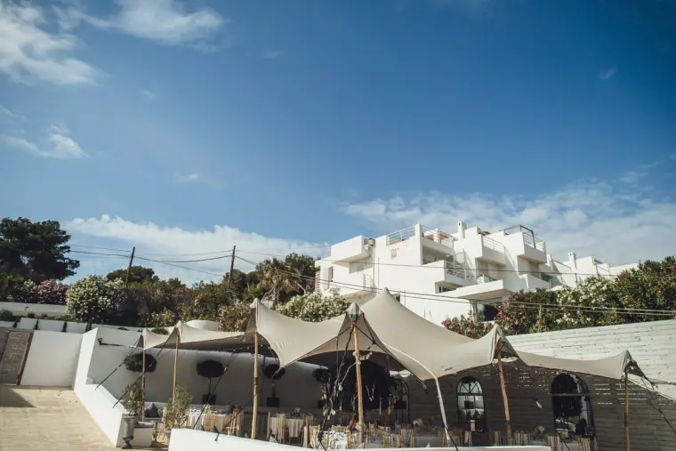 Stretch tents and white villa buildings at Elixir Shore Club under a blue sky