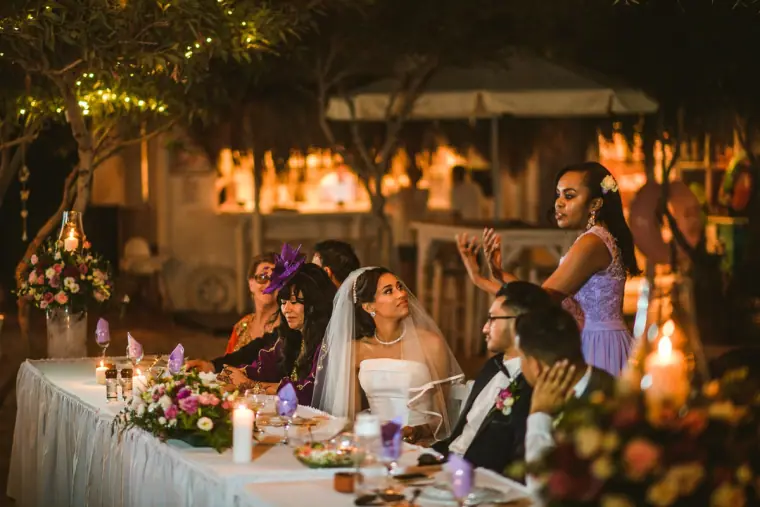 Bride and guests laughing during the speeches at the candlelit top table