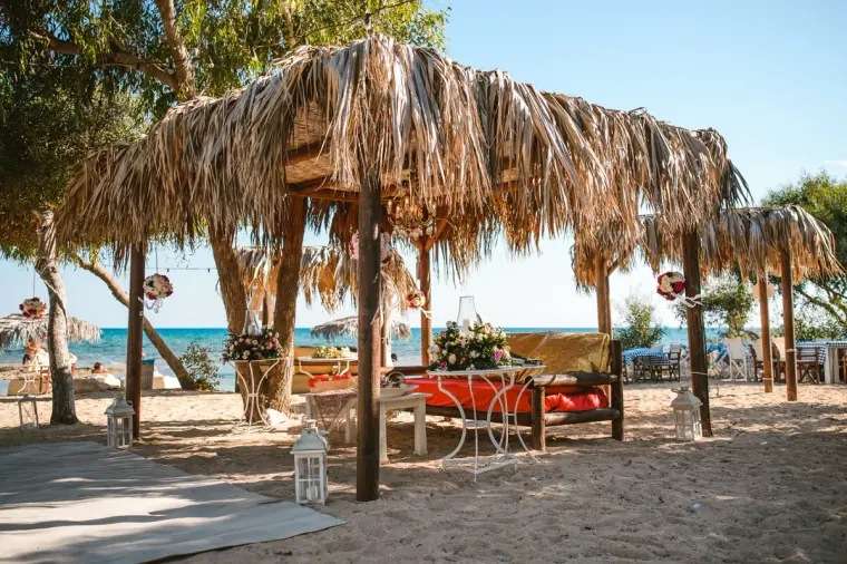Thatched beach canopy dressed with red cushions and flowers for the traditional ceremony