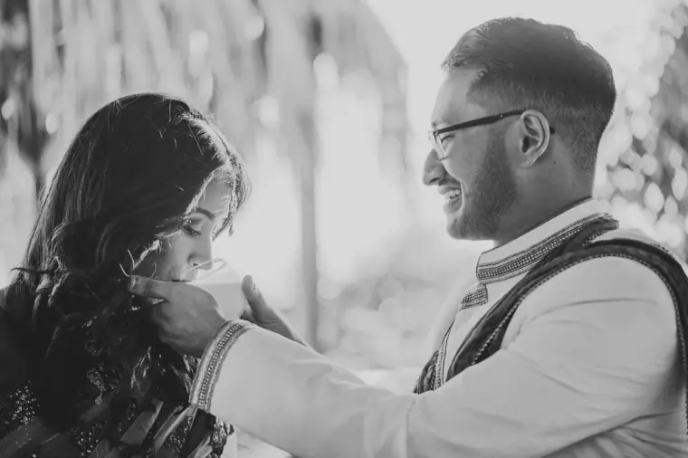 Black-and-white photo of the groom feeding the bride during the ceremony