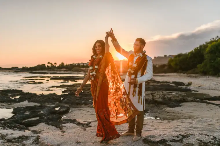 Groom twirling the bride on the rocky shore at sunset, Thalassines Beach Villas