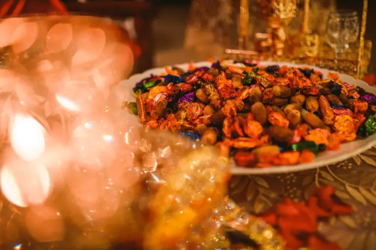 Platter of dried fruit and nuts glowing among golden bokeh lights