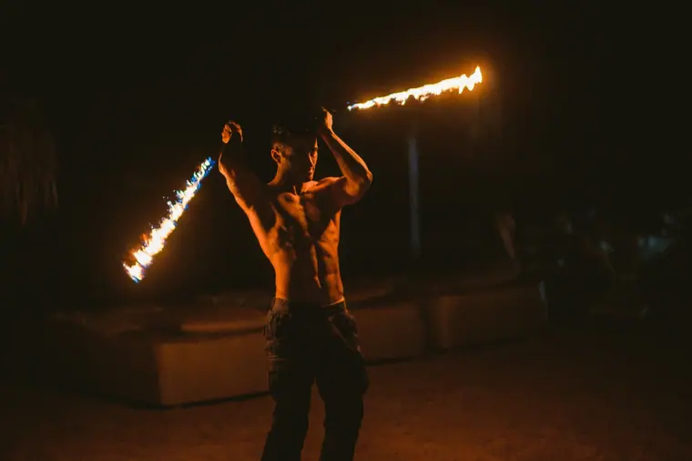 Fire performer spinning a staff that leaves trails of flame