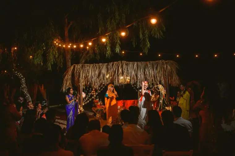 Guests gathered around the fairy-lit thatched canopy for the evening dance