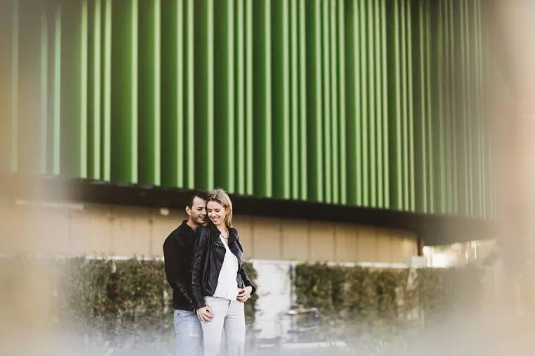 Joanna and Andrew standing together beneath a green slatted building facade, Paphos