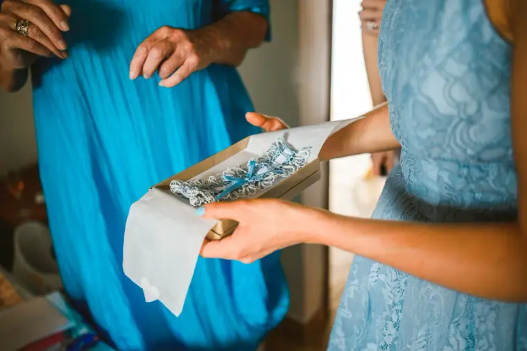 Bridesmaids in blue unwrapping a gift in tissue paper