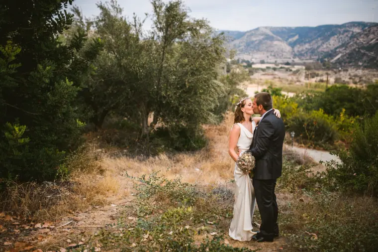 Couple kissing on a country track with mountains behind, Nikokleia