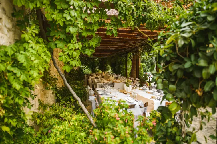 Long reception table under a vine-covered pergola at Vasilias Nikoklis Inn