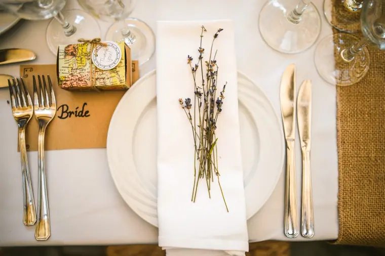 Bride's place setting with a lavender sprig, kraft name card and gold favour box