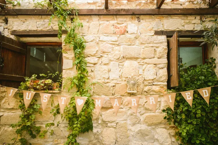 Stone wall with a hand-lettered bunting banner above the reception