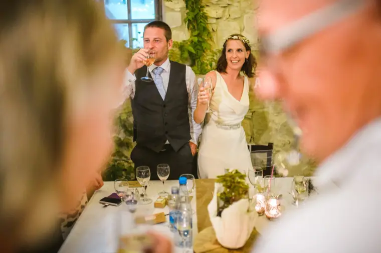 Bride and groom raising their glasses to toast their guests