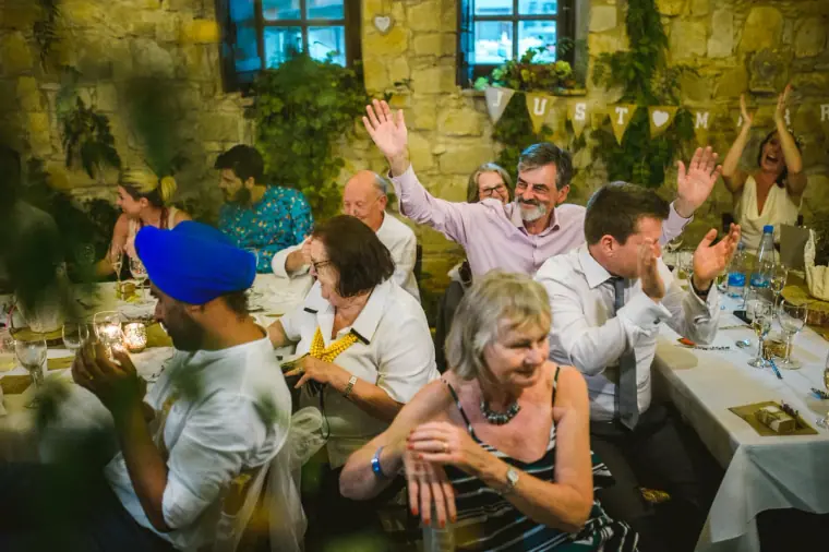 Guests cheering and waving their arms at the reception in the courtyard