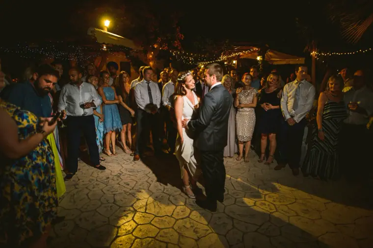 Bride and groom's first dance in the courtyard surrounded by guests at night