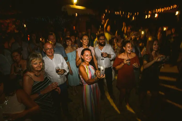 Guests watching the evening entertainment, smiling beneath strings of lights