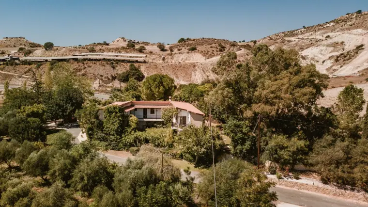 Hillside view over trees to Vasilias Nikoklis Inn and the surrounding valley