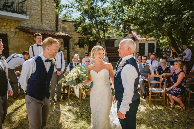 Bride's father handing her to the groom at the end of the aisle