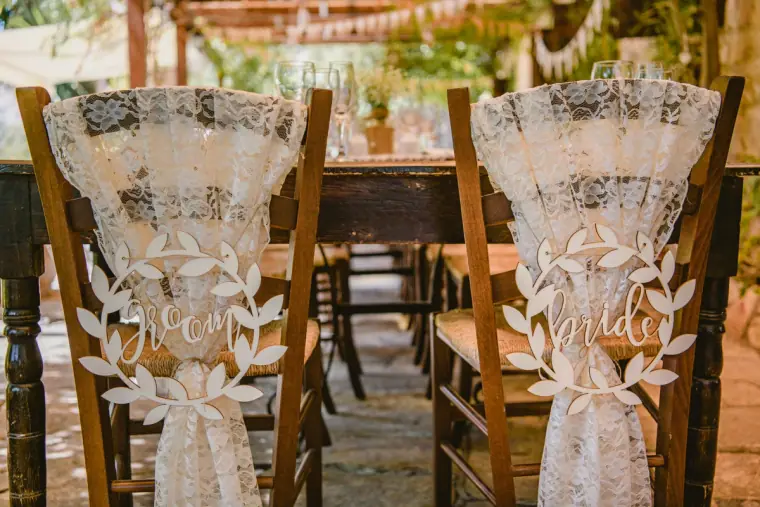 Mr and Mrs chair covers in lace on wooden chairs at the top table
