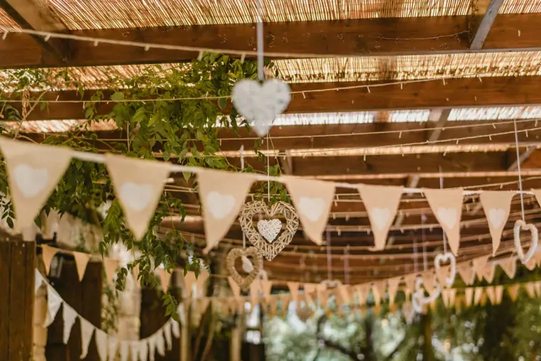 Hessian bunting and heart decorations strung beneath a reed pergola