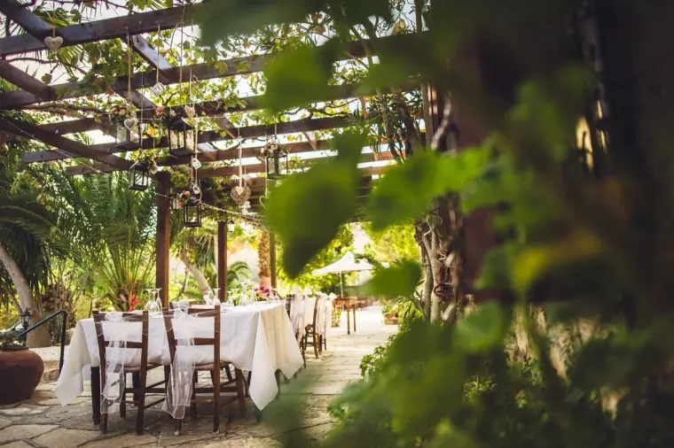 Reception tables beneath a leafy pergola in the inn's courtyard