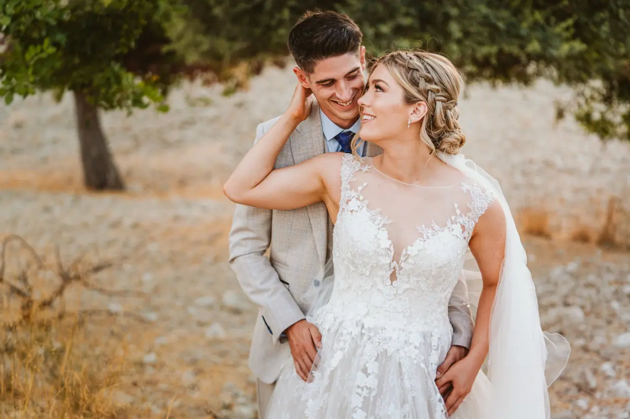 Chloe and Liam embracing in a golden field near Vasilias Nikoklis Inn, Paphos