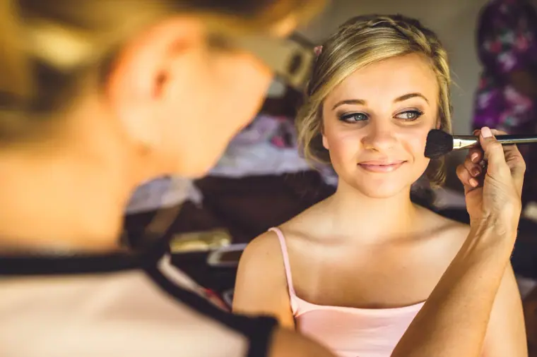 Bridesmaid having her make-up applied while getting ready