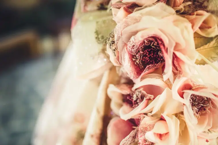 Close-up of the soft pink fabric flowers adorning the wedding dress