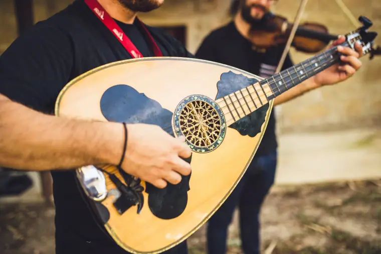 Musician playing a Cypriot laouto beside a violinist
