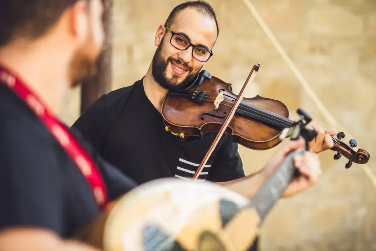 Violinist and laouto player performing traditional music in the courtyard