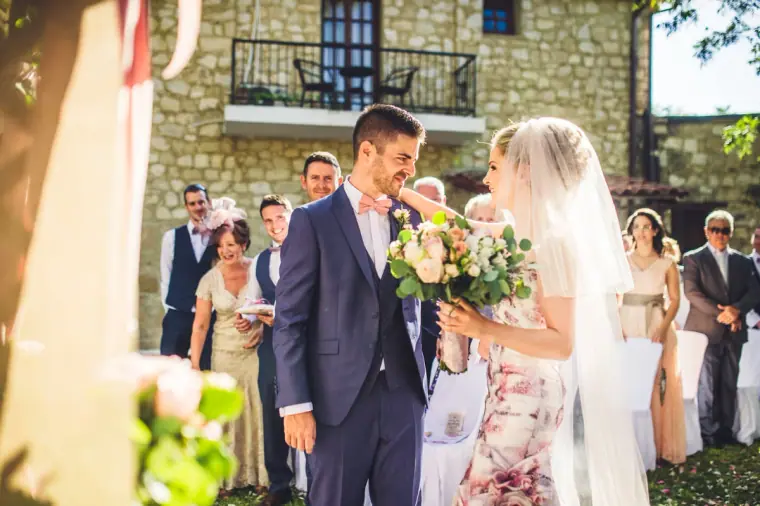 Groom turning to greet the bride at the top of the aisle in the inn's garden