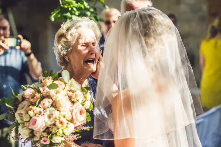 Guest in tears of joy hugging the bride after the ceremony