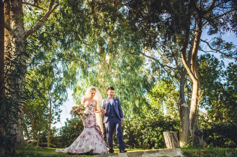 Alex and Anthony standing together under towering eucalyptus trees