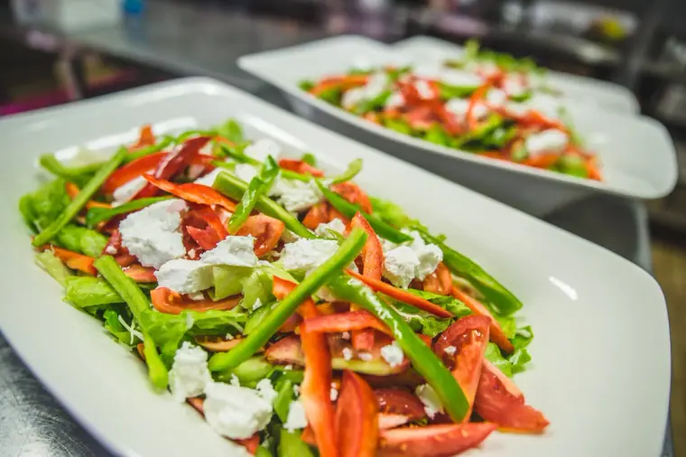 Platter of fresh salad with red pepper, green beans and crumbled feta