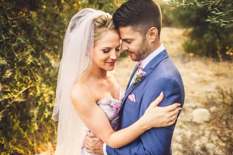 Bride and groom touching foreheads in warm afternoon light