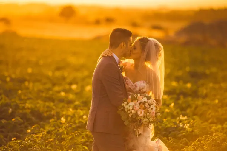 Couple kissing in a golden glowing field at sunset in the Paphos countryside