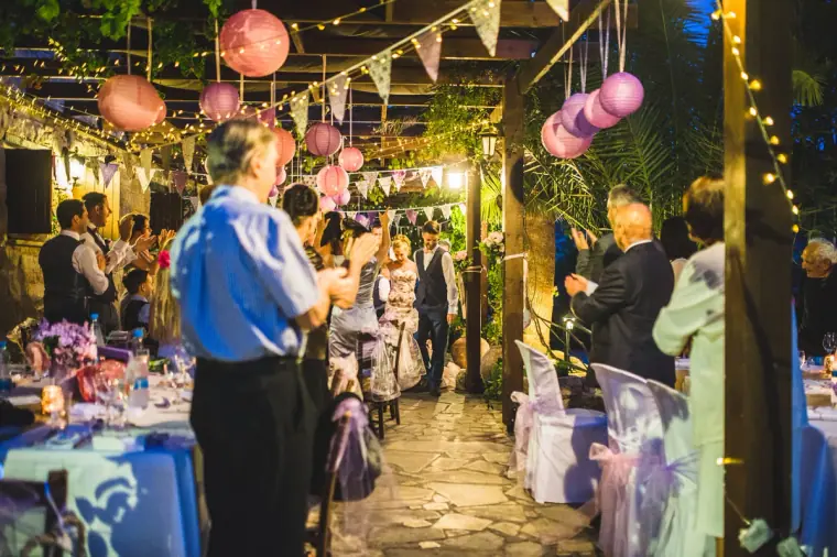 Guests mingling along the lantern-lit pergola before dinner