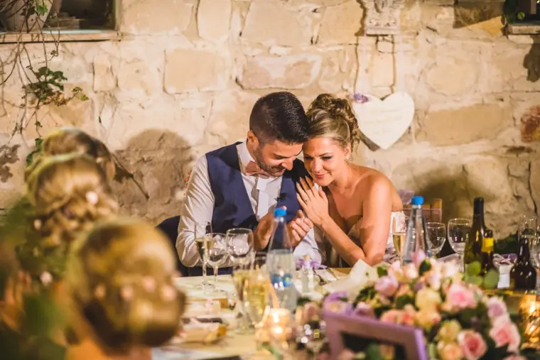 Bride and groom laughing together at the top table during speeches