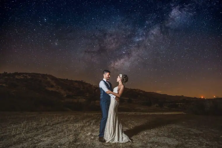 Alex and Anthony under a starry night sky and the Milky Way above the Paphos hills