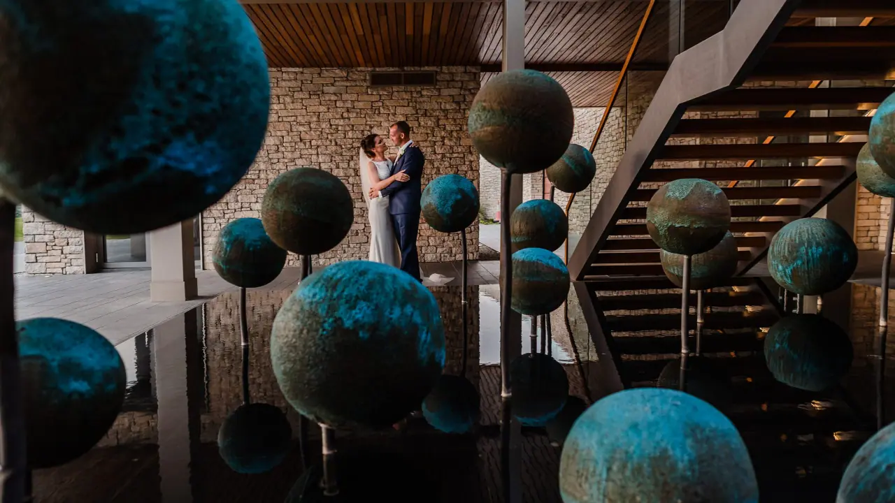 Kaye and Matt in the lobby of Minthis Hills, Tsada, among hanging teal sphere sculptures