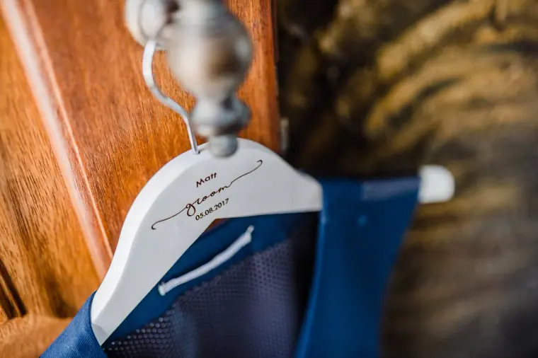Navy suit jacket on a personalised white wooden hanger