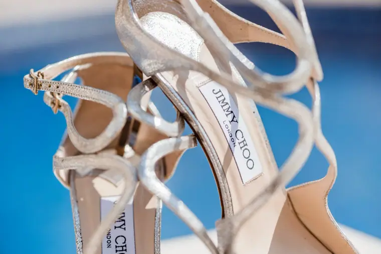 Silver Jimmy Choo sandals against the blue of the swimming pool
